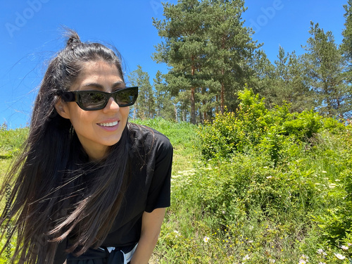 Beautiful Woman with black sunglasses in the summer mountain 