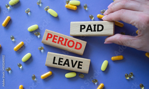 Paid Period Leave symbol. Concept words Paid Period Leave on wooden blocks. Beautiful purple background with pills. Doctor hand. Healthcare and Paid Period Leave concept. Copy space. photo