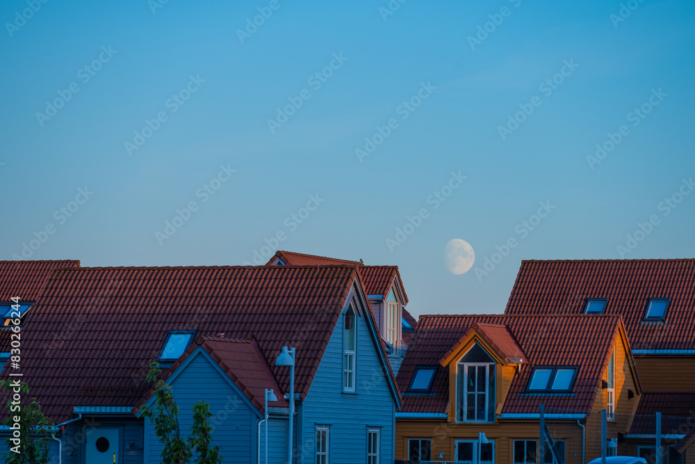 The moon rising over a row of summer houses. The moon rising over a row of summer houses.