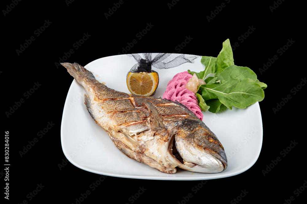 Grilled gilthead sea bream on plate with lemon ,salad and grilled vegetables. Fried sea bream on plate with a lemon. Healthy food. Grilled gilthead sea bream on plate with lemon ,salad and grilled vegetables. Fried sea bream on plate with a lemon. Healthy food.