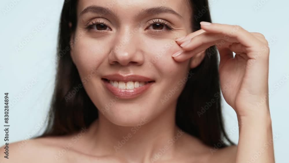 Closeup of a beautiful young woman touching her cheek, portraying skincare and beauty concepts with a serene expression. Closeup of a beautiful young woman touching her cheek, portraying skincare and beauty concepts with a serene expression.