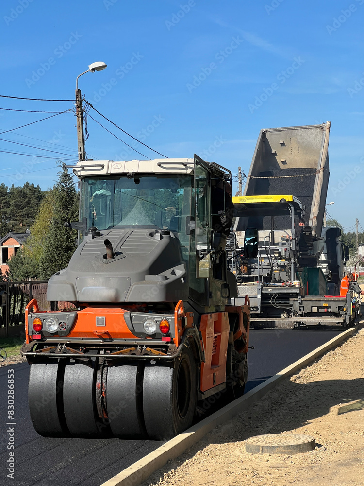 Construction of a new street surface. Laying a layer of asphalt with a specialized machine Construction of a new street surface. Laying a layer of asphalt with a specialized machine