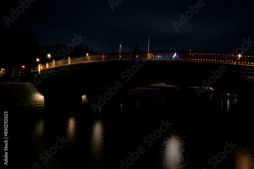 Ha'penny Bridge of the River Liffey in Dublin Ireland in the evening with lights and reflections photo