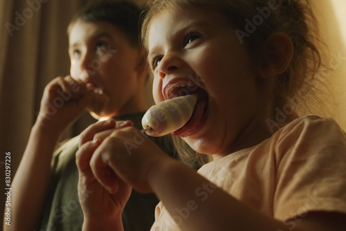 A boy and a girl are having fun sharing ice cream together