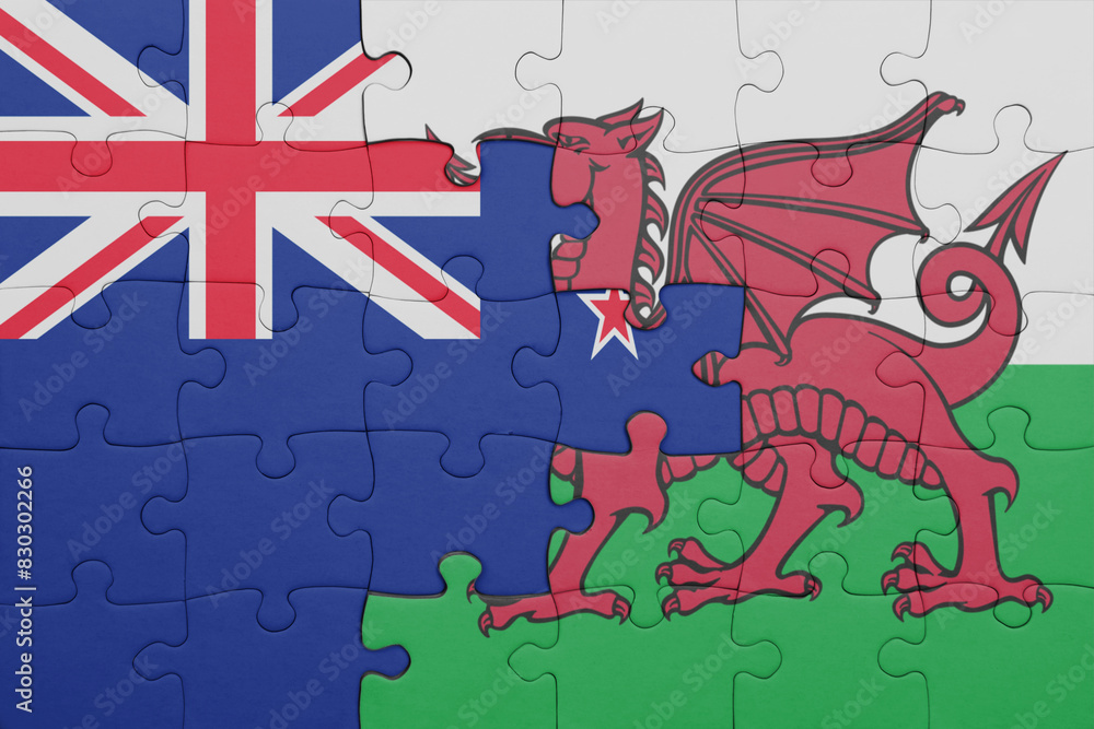 Φωτογραφία puzzle with the colourful national flag of wales and flag of new zealand