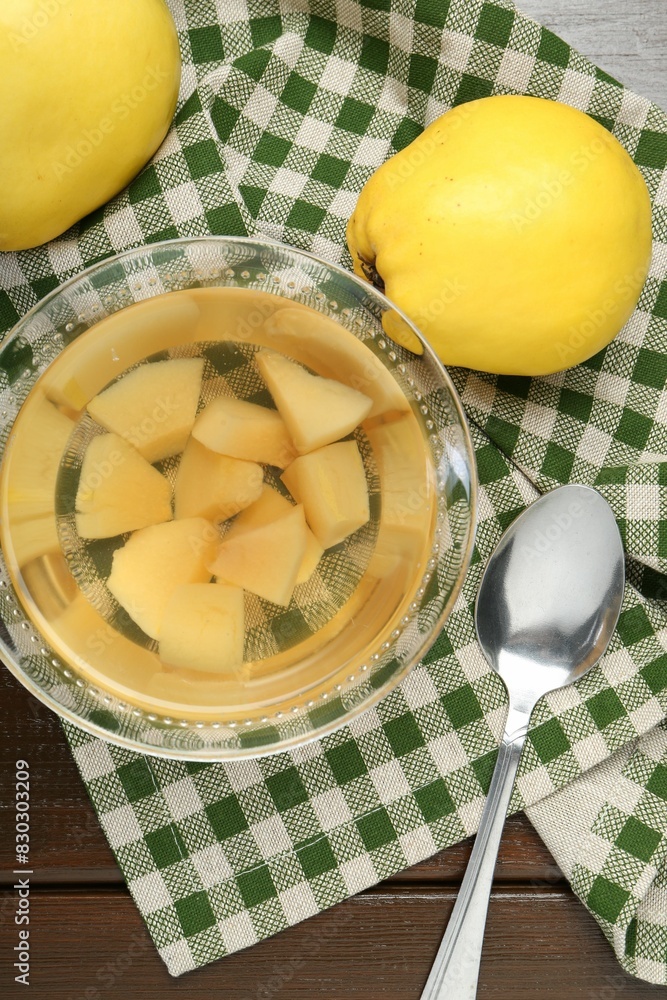 Delicious quince drink in glass bowl, fresh fruits and spoon on wooden table, top view Delicious quince drink in glass bowl, fresh fruits and spoon on wooden table, top view