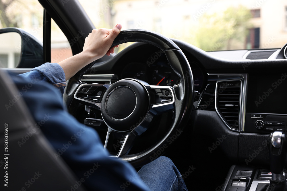 Woman holding steering wheel while driving her car, closeup Woman holding steering wheel while driving her car, closeup