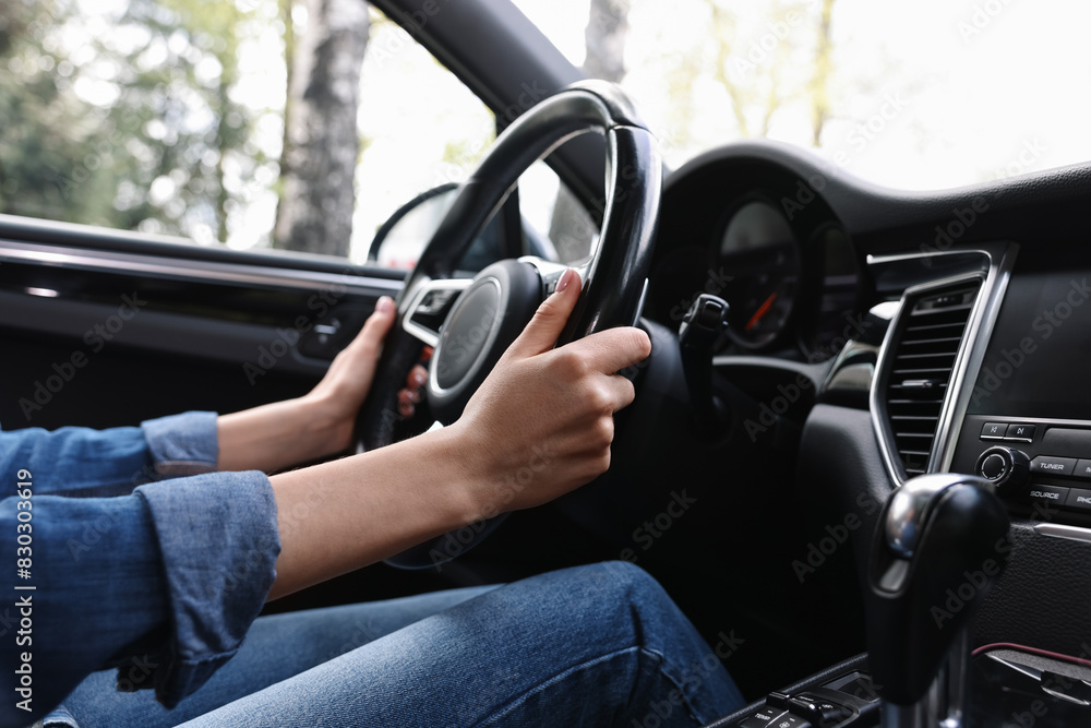 Woman holding steering wheel while driving her car, closeup Woman holding steering wheel while driving her car, closeup