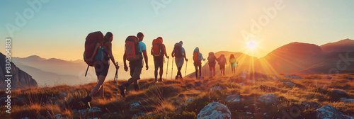Group of tourists walking atop of a mountain on sunny sunset.