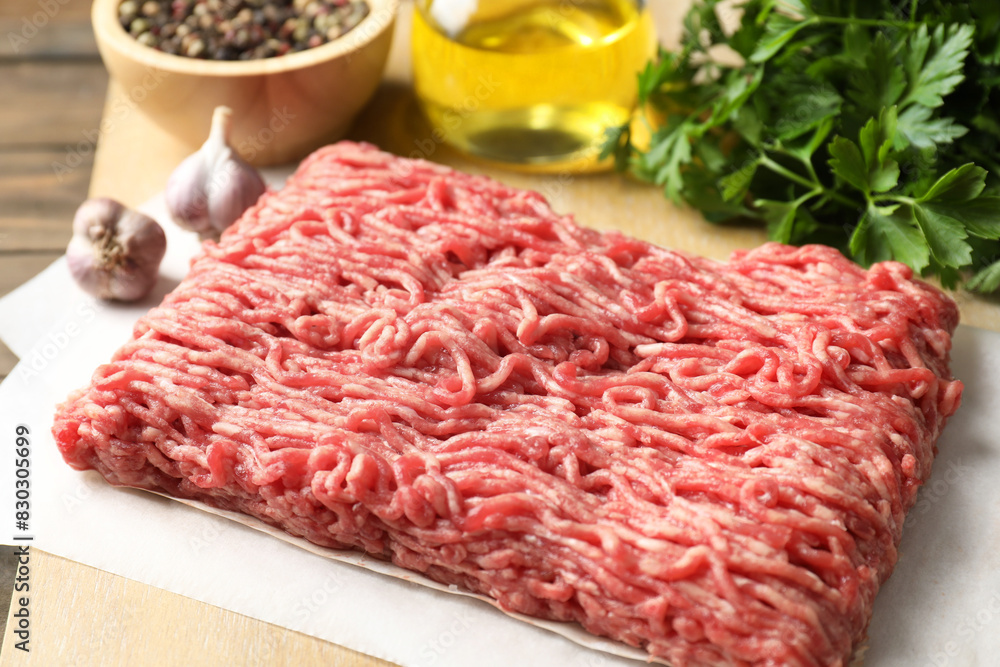 Raw ground meat, parsley and garlic on table, closeup Raw ground meat, parsley and garlic on table, closeup