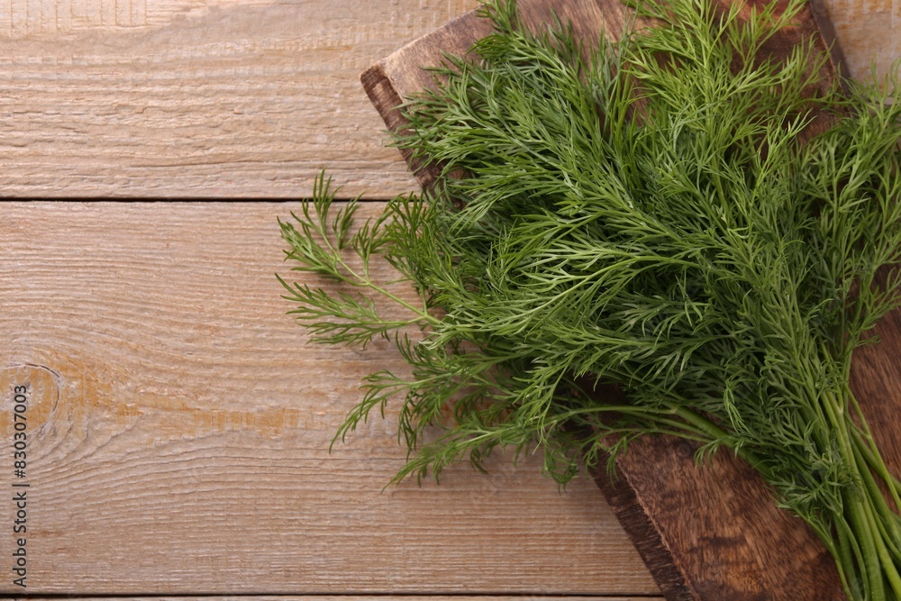 Board with sprigs of fresh dill on wooden table, top view. Space for text Board with sprigs of fresh dill on wooden table, top view. Space for text