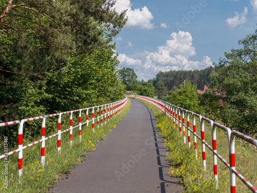 Obraz na płótnie Asphalt bicycle road with parallel barriers. Cycling route between Obrzycko and Oborniki. Summer countryside landscape in Wielkopolska region, Poland. w salonie