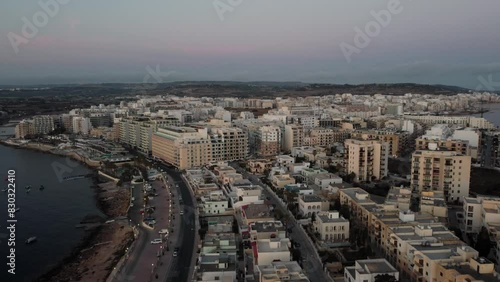 Wallpaper Mural Qawra cityscape in the early morning, during the sunrise. Revealing empty coastal road in golden hour. Aerial. High quality 4k footage Torontodigital.ca
