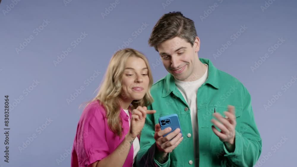 Young couple using mobile device. Woman man watching, laughing with smartphone
