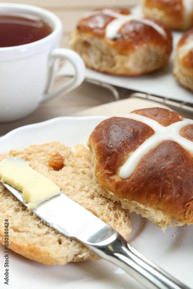 Tasty hot cross bun served on table, closeup Tasty hot cross bun served on table, closeup