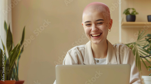 Happy young female student working on laptop. Smiling gay lesbian with pink hair on virtual video call team meeting with colleagues. Inclusive & diverse remote workplace photo