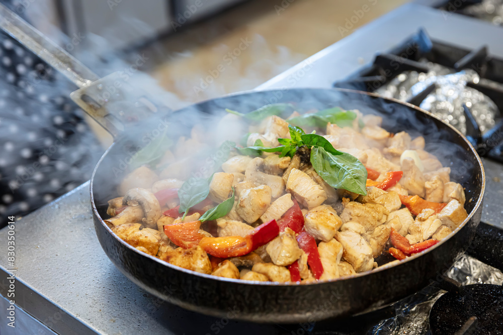 Chef is preparing chicken sauté. Lady Chef's hand sautéing ingredients in a pan. Healthy food concept. Chef is preparing chicken sauté. Lady Chef's hand sautéing ingredients in a pan. Healthy food concept.