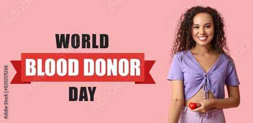 Female African-American blood donor with applied medical patch on her hand and heart. World Blood Donor Day