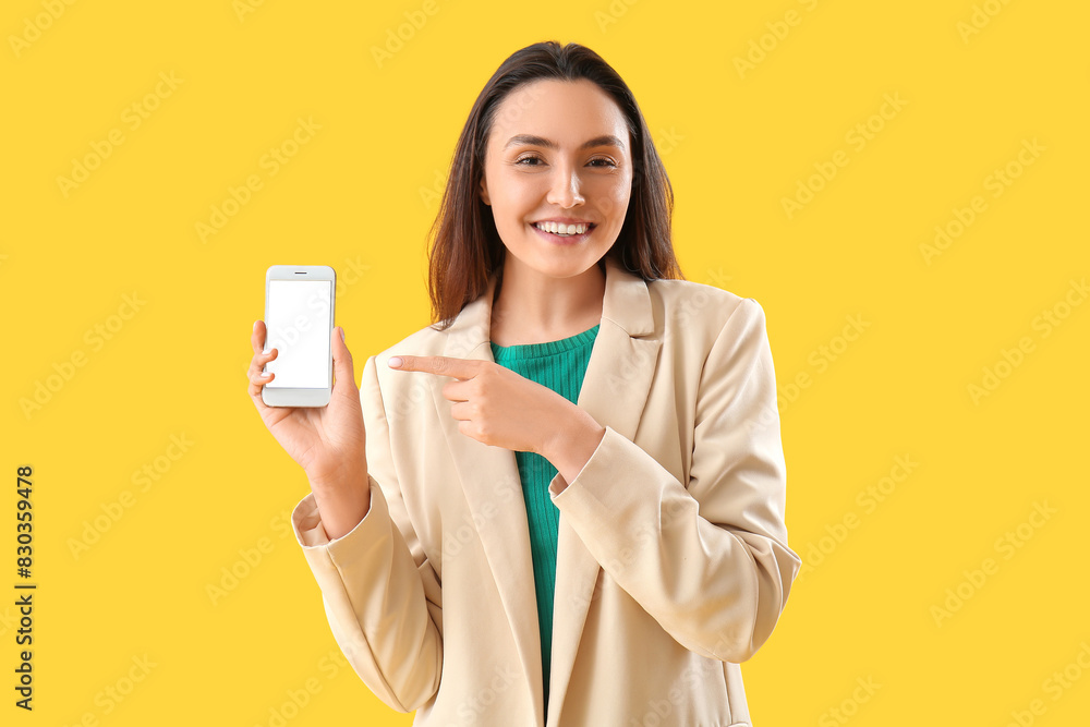 Happy young woman with smartphone on yellow background Happy young woman with smartphone on yellow background