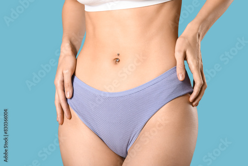 Young woman in panties on blue background © Pixel-Shot