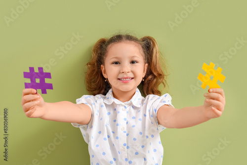 Cute little girl with hashtags on green background