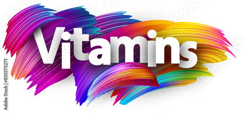 Vitamins paper word sign with colorful spectrum paint brush strokes over white.