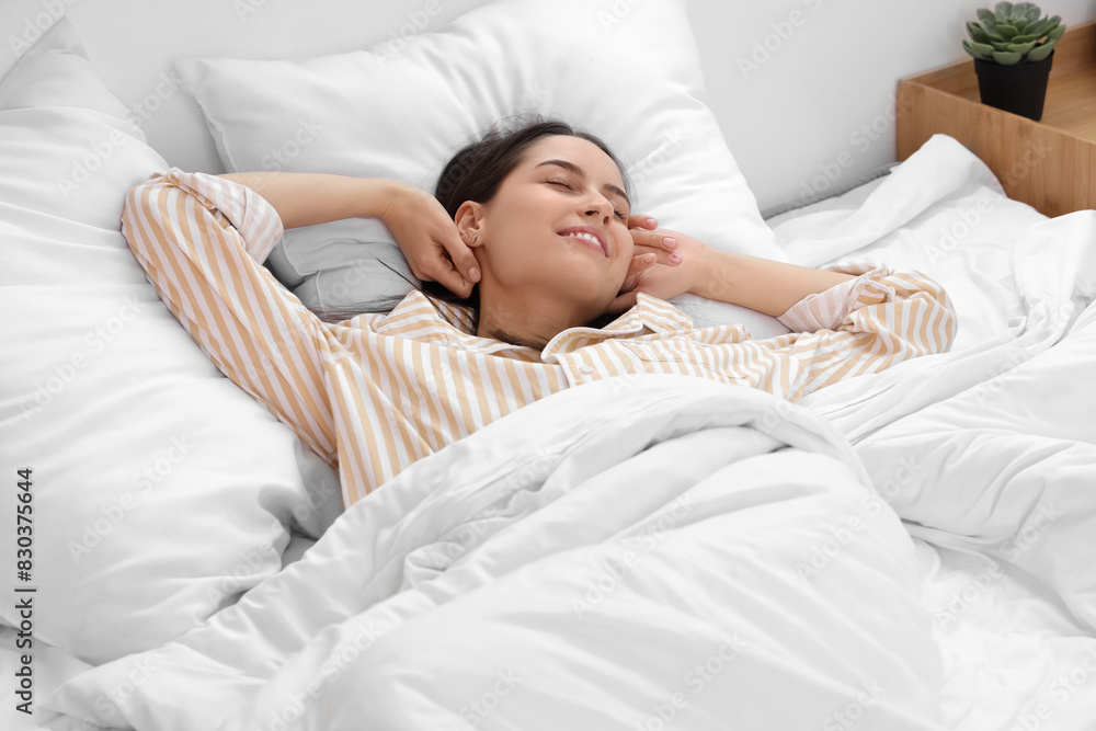 Happy young woman lying in bed Happy young woman lying in bed