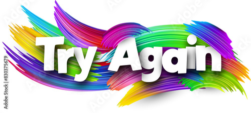 Try again paper word sign with colorful spectrum paint brush strokes over white.