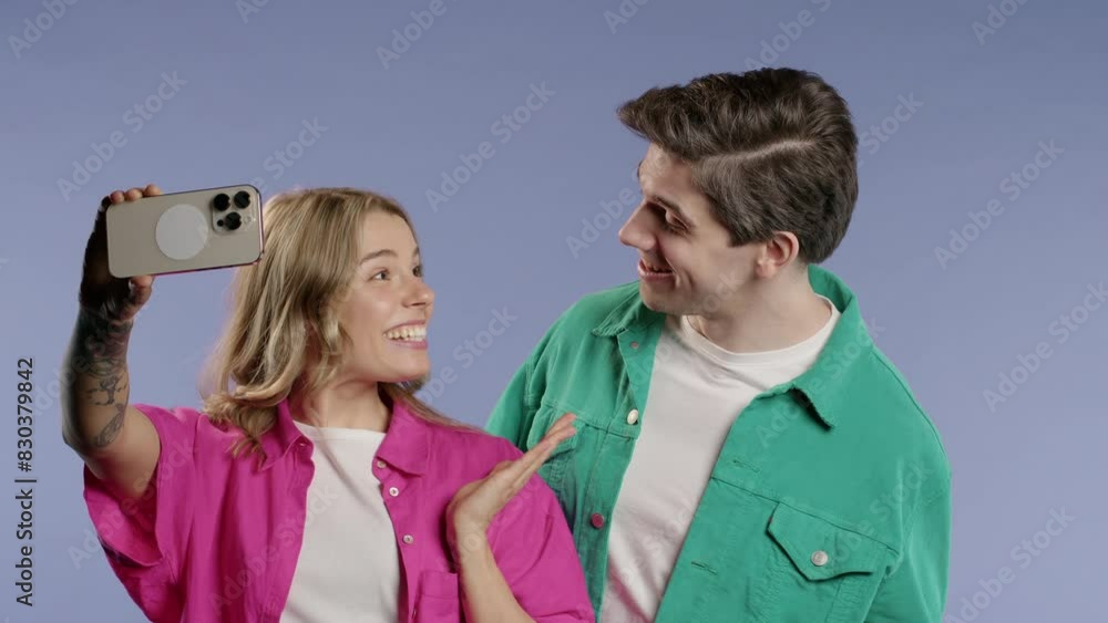 Happy couple talking camera as video call,record vlog as bloggers on violet wall Happy couple talking camera as video call,record vlog as bloggers on violet wall