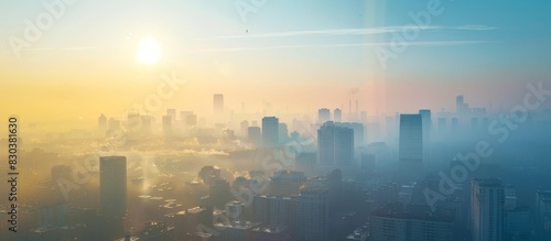 A city skyline with a bright orange sun in the background. The sky is hazy and the sun is low on the horizon