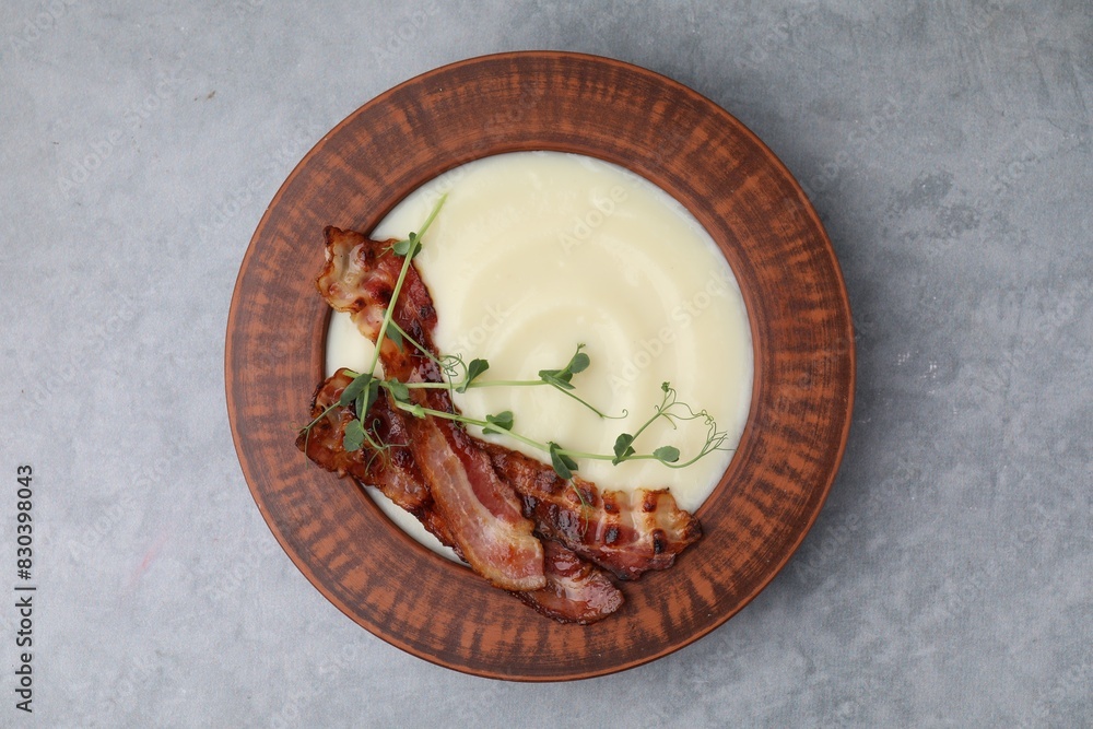 Delicious potato soup with bacon and microgreens in bowl on gray table, top view Delicious potato soup with bacon and microgreens in bowl on gray table, top view