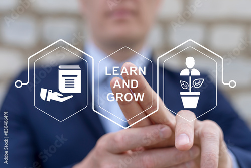 Learn and grow business finance education concept. Man using virtual touch screen presses inscription: LEARN AND GROW. photo