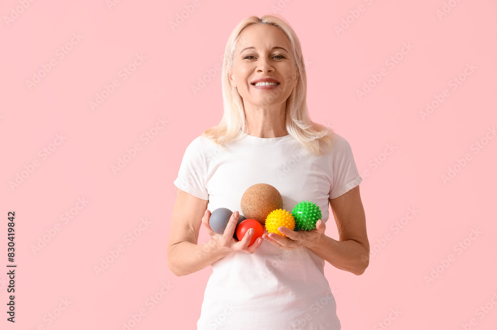 Mature woman with massage balls on pink background Mature woman with massage balls on pink background