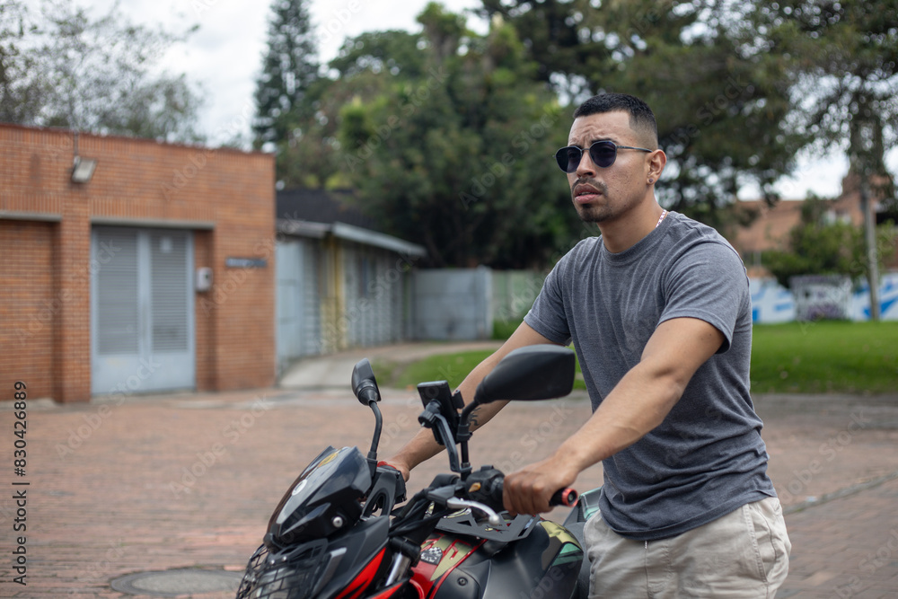 young motorcyclist man with glasses with his motorcycle on the street about to start a biker trip young motorcyclist man with glasses with his motorcycle on the street about to start a biker trip