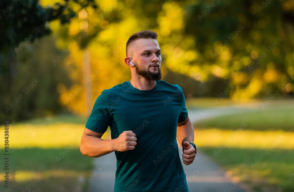 A young athletic man running or jogging at the park active healthy lifestyle. A young athletic man running or jogging at the park active healthy lifestyle.