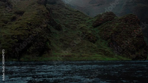 Skoga River flowing from Skogafoss waterfall in Iceland on a dark, cloudy morning. Perfect for relaxation and meditation. photo
