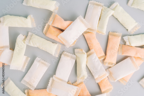 Lots of snus bags with fruit and mint flavors on a light background.