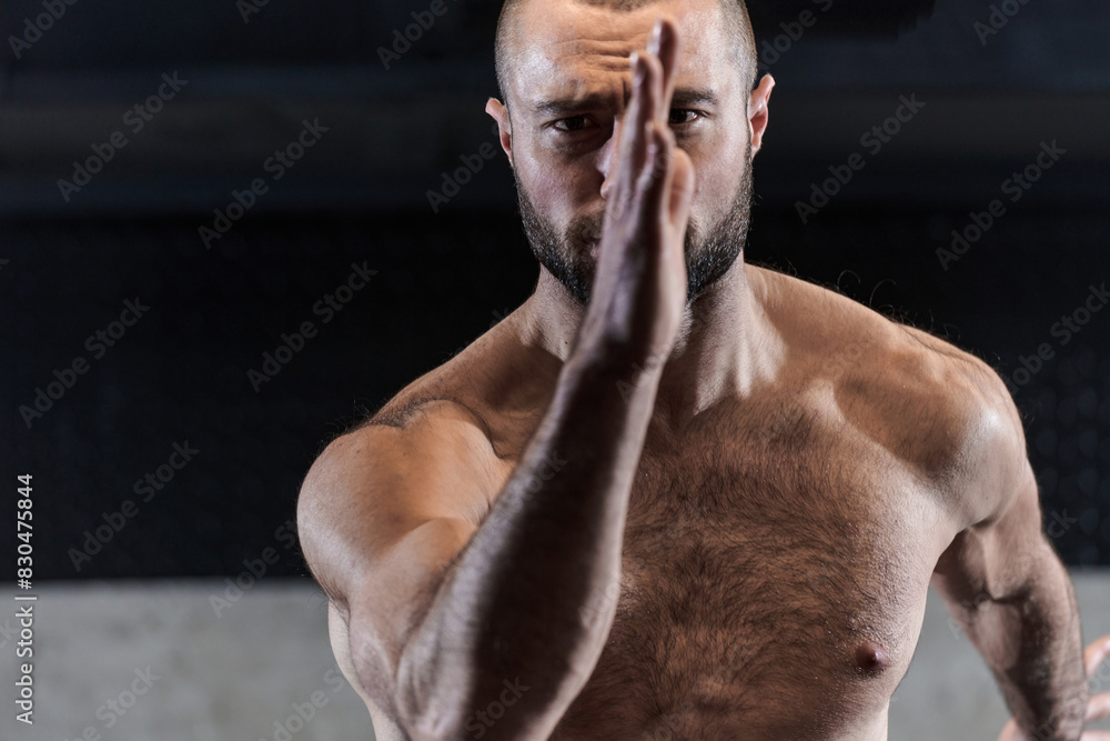 A muscular man standing in the starting position for running, exuding determination and readiness for an intense fitness workout or athletic competition.