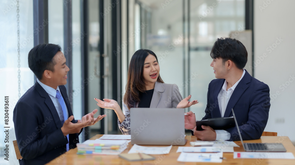 Business professionals in a meeting, discussing ideas and strategies with laptops and documents in a modern office setting. Business professionals in a meeting, discussing ideas and strategies with laptops and documents in a modern office setting.