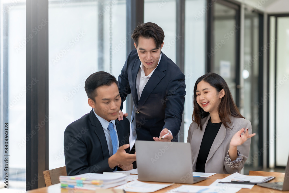 Three business professionals collaborating in a modern office, working on a laptop and discussing strategies for an important project. Three business professionals collaborating in a modern office, working on a laptop and discussing strategies for an important project.