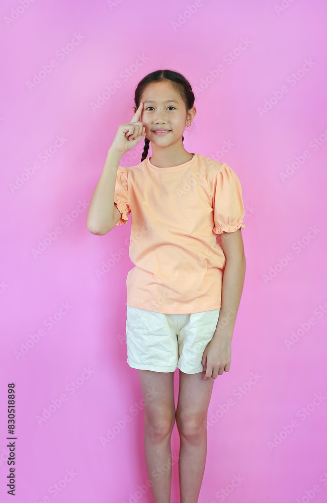 Portrait of Asian young girl child think gesture with index finger point brain head isolated on pink studio background. Portrait of Asian young girl child think gesture with index finger point brain head isolated on pink studio background.