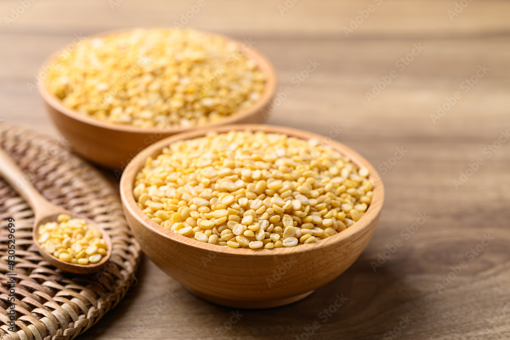 Yellow peeled split mung bean in bowl on wooden background, Food ingredient Yellow peeled split mung bean in bowl on wooden background, Food ingredient
