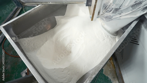Plastic powder at factory. Creative. Pipe with spilling plastic powder at factory. Process of industrial extrusion in chemical shop of metallurgical production