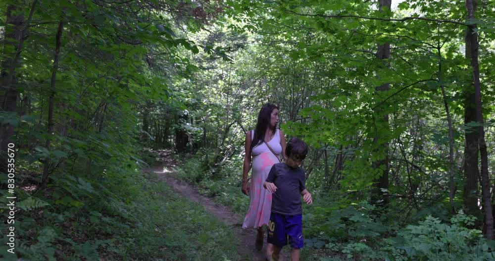 Pregnant mother on nature walk with son - wide shot Pregnant mother on nature walk with son - wide shot