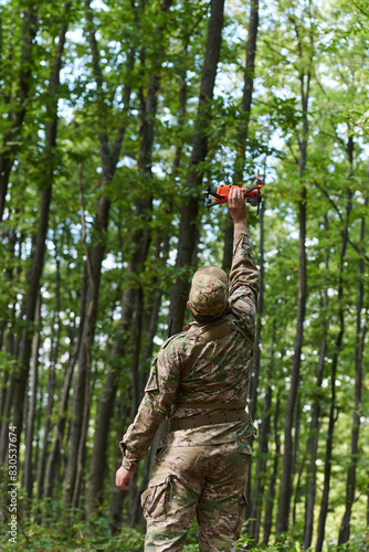 Elite military unit  equipped with state-of-the-art technology including a drone  strategically navigates and surveys dangerous wooded terrain  showcasing their precision  cooperation  and specialized