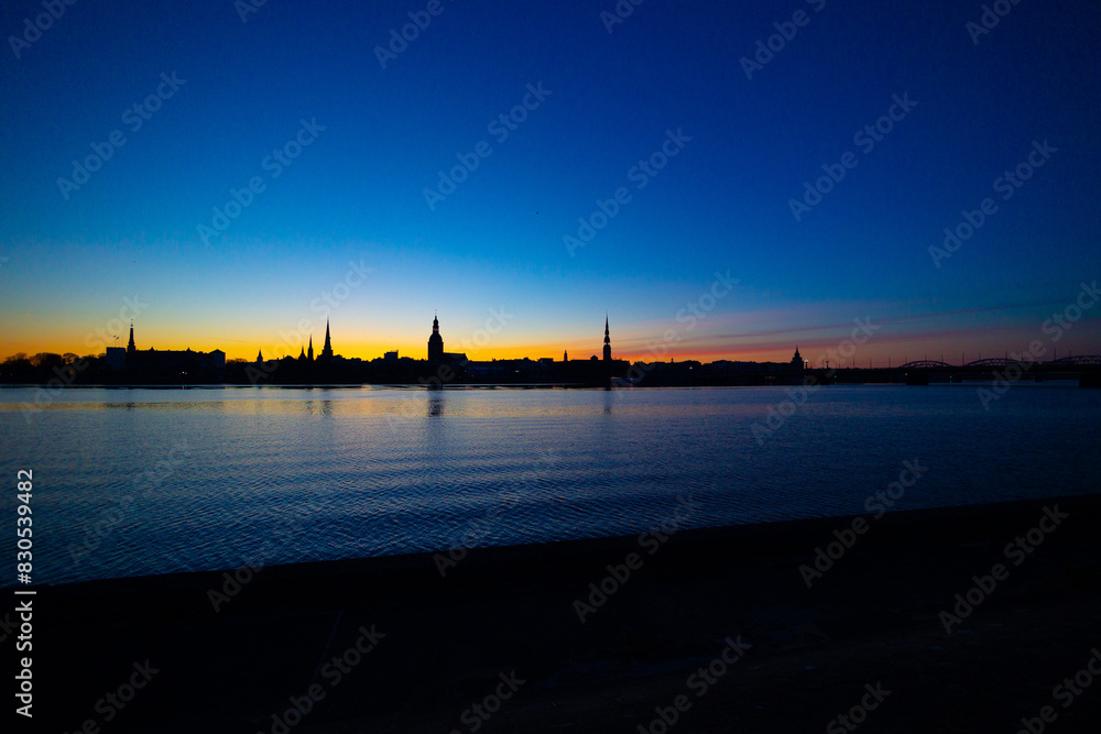 Fototapeta premium A beautiful Riga cityscape during colorful sunrise. Buildings against colorful sky. Northern Europe morning with warm sky.