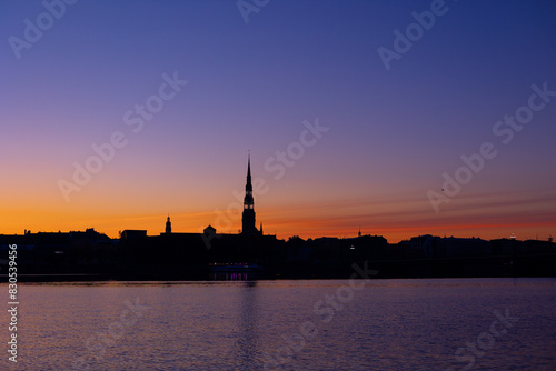 A beautiful Riga cityscape during colorful sunrise. Buildings against colorful sky. Northern Europe morning with warm sky.