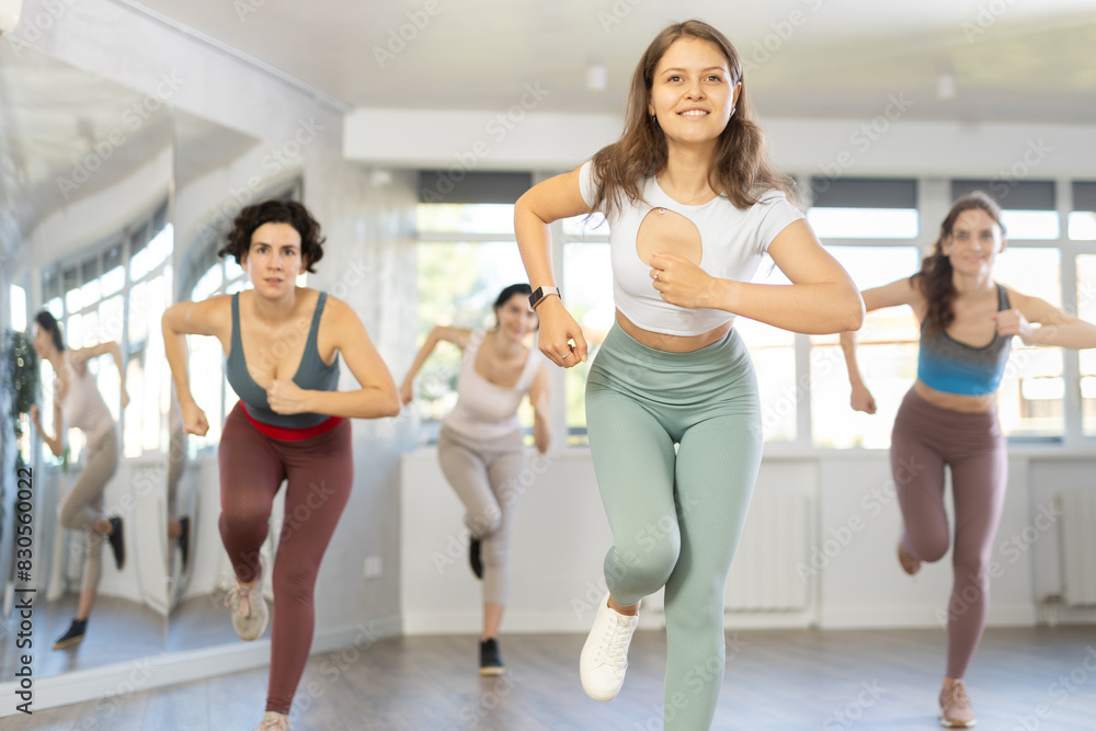 Group of women learning modern dance movements at class together