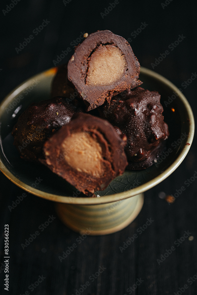 A still life of chocolate truffles with liquid filling at dark background A still life of chocolate truffles with liquid filling at dark background