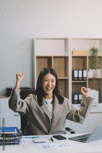 Beautiful Asian girl celebrate with laptop, success happy pose. E-commerce, university education, internet technology, or startup small business concept. Modern office or living room with copy space